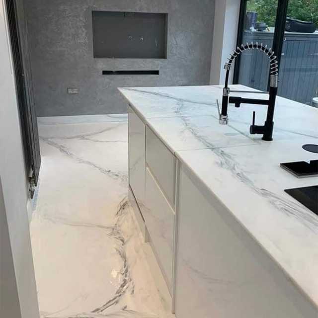 una cucina con pavimento e top in resina effetto marmo bianco con striature grigie