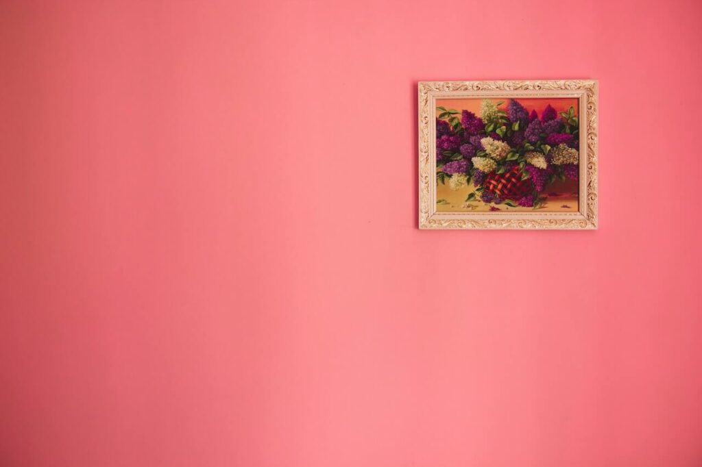 muro con pittura lavabile rosa e un quadro dorato sulla destra